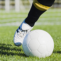 Low section view of a soccer player kicking a soccer ball