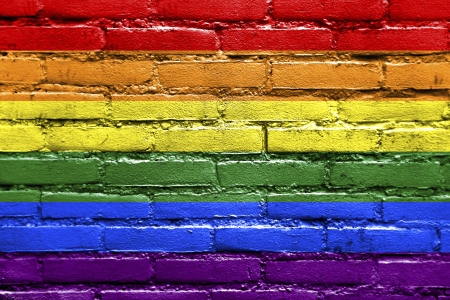 A brick wall with the rainbow flag painted on it
