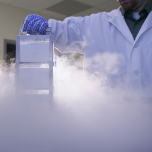 Scientist removing samples from a storage tank of liquid nitrogen