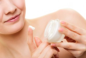 Female applying face cream from a jar