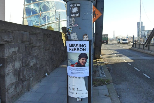 poster of a missing person on a lamp post