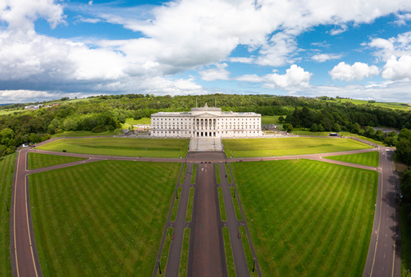 Aerial view of Stormont Parliament Buildings in Belfast Northern Ireland. Green fields against blue sky
