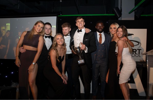 Members of the strength and conditioning club with their top club trophy at awards ceremony