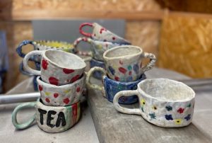 Piles of homemade mugs on a table