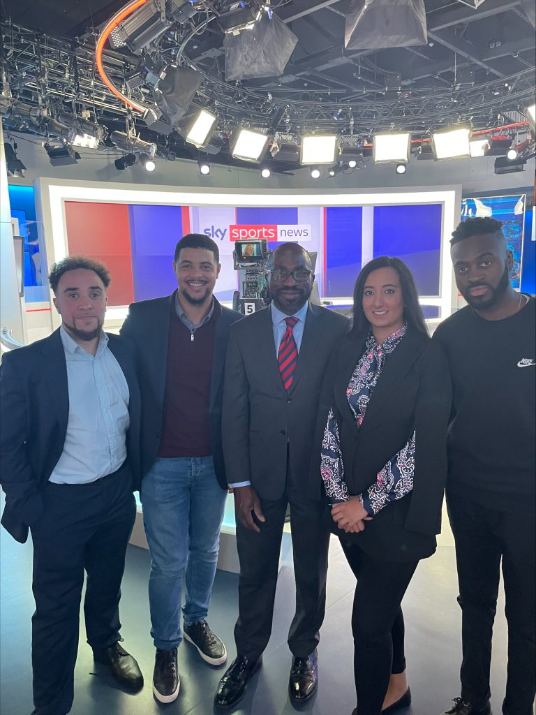 The four Scholars and Tunde in front of a Sky Sports sign