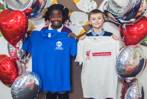 two children holding LFC and EFC tops