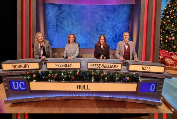 University challenge contestants on the Hull panel with a Christmas tree in the background