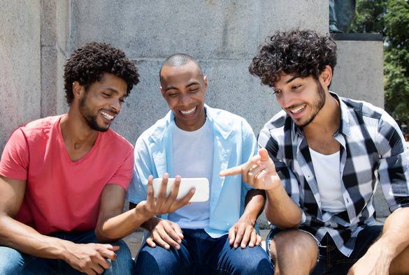A group of men looking at a phone