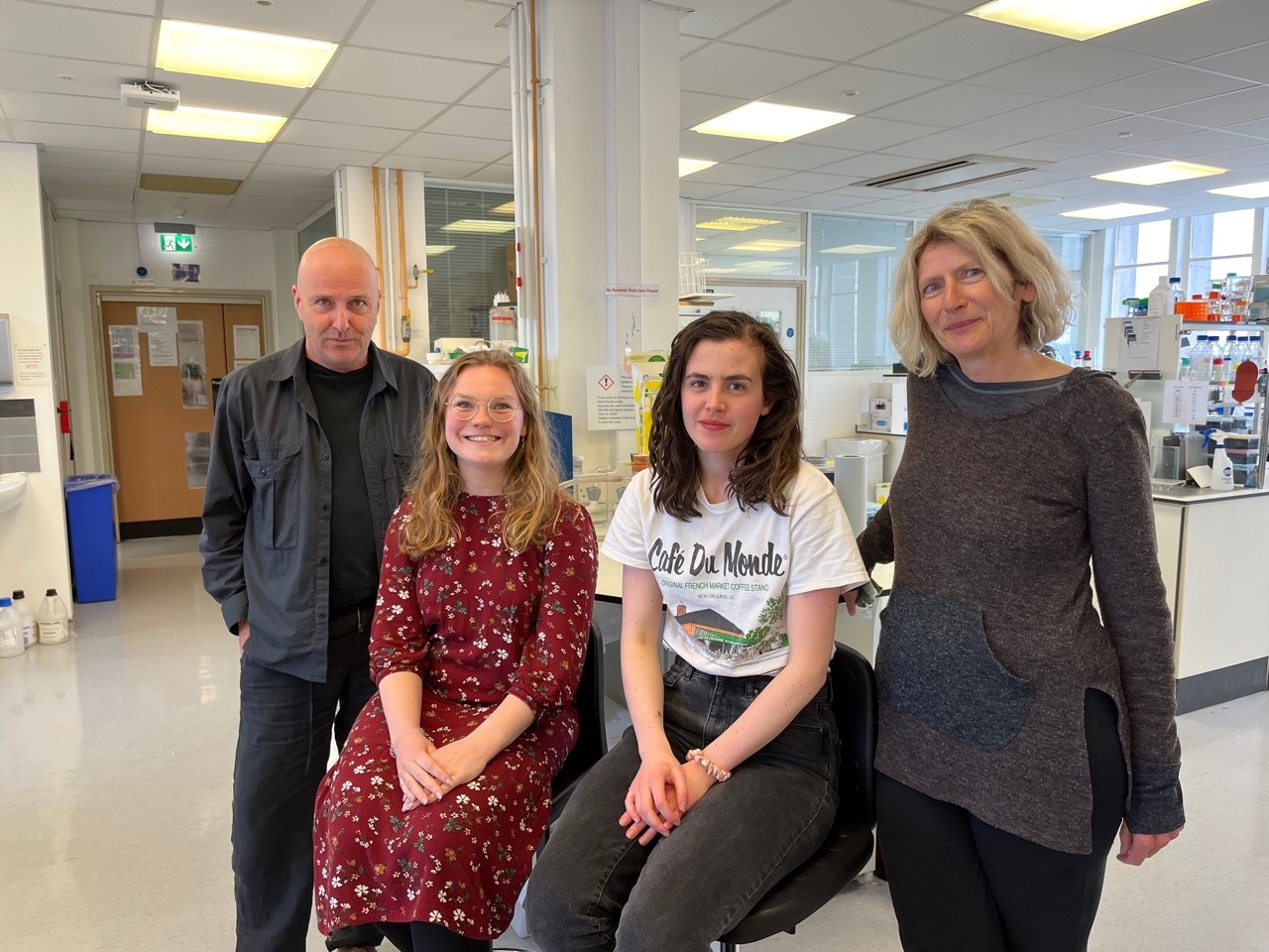 Study team standing in a lab. L-R: Prof Michael Clague (PI and co-corresponding author) Dr Hannah Elcocks (Post-doctoral researcher, first author) Ms Katy McCarron (PhD student, co-author) Prof Sylvie Urbé (PI and co-corresponding author) 