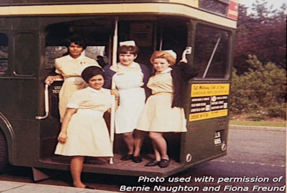 A picture of four women in nurses uniforms on a bus
