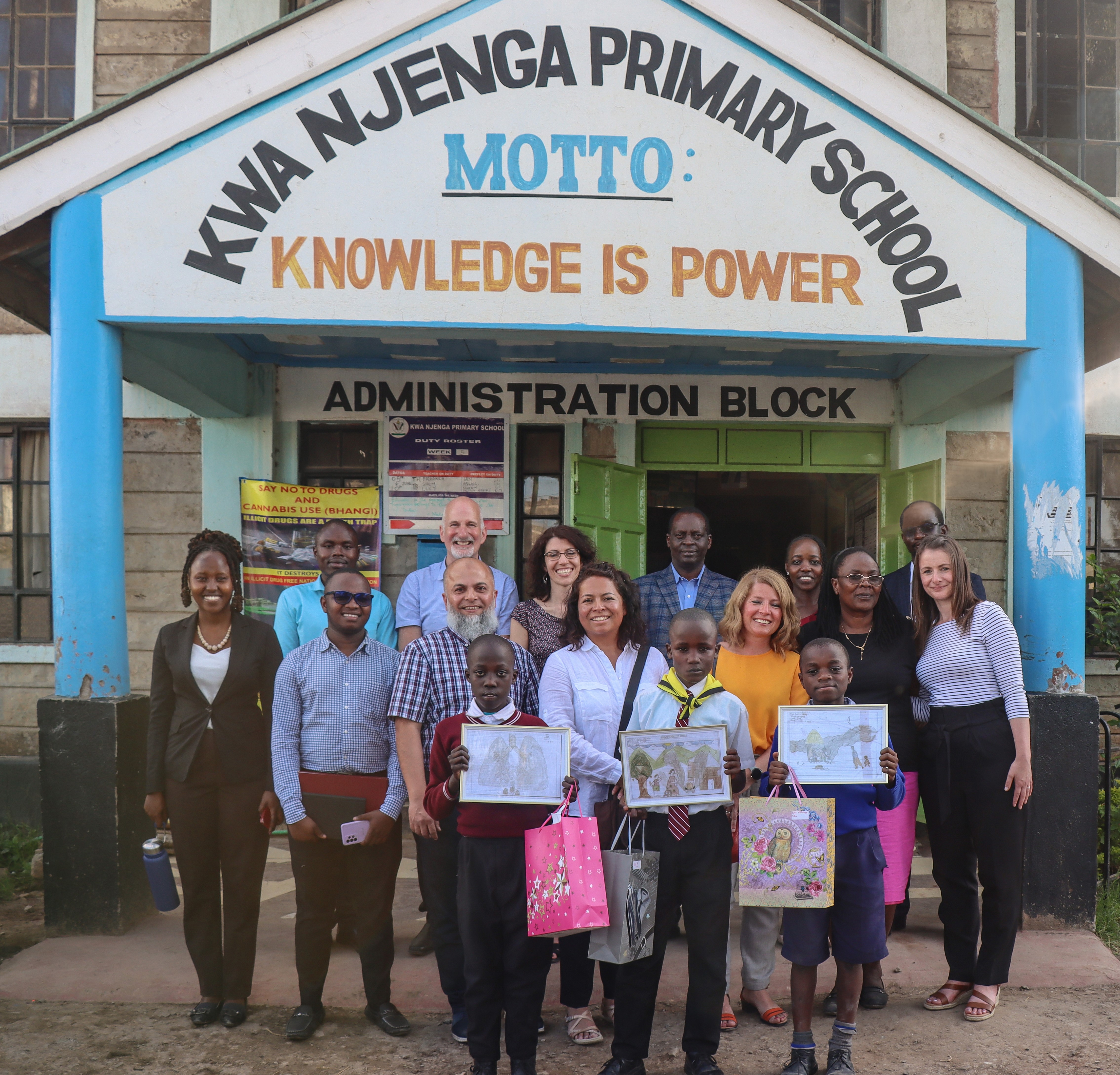 Group stand outside school in Kenya 