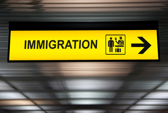 An immigration sign with a yellow background at an airport
