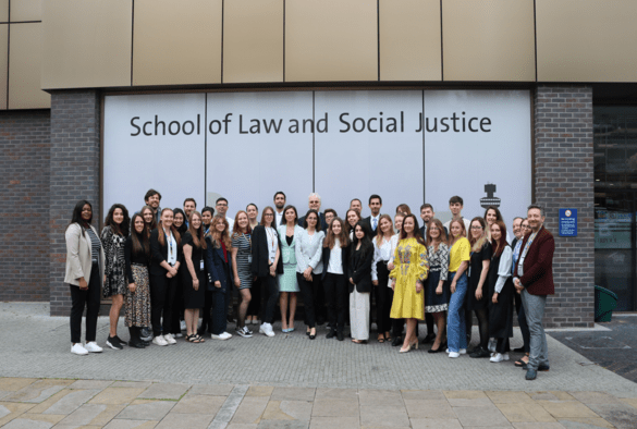 A group photo outside of the School of Law and Social Justice with conference attendees