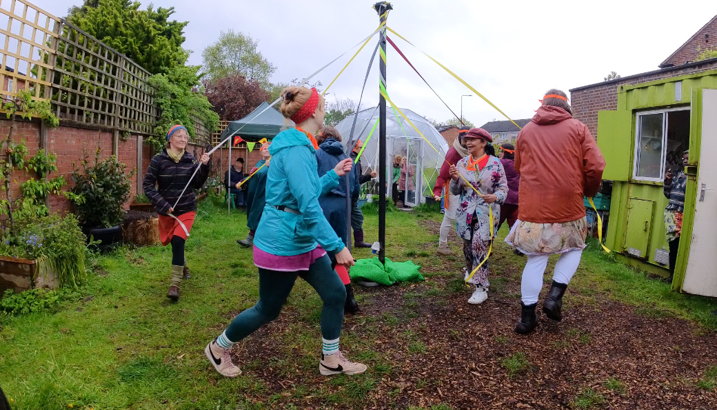 People dancing around a maypole 