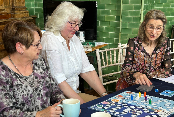 Group of ladies play board game at table