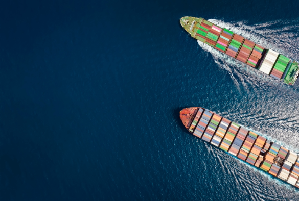 An aerial photo of shipping containers on boats on the sea