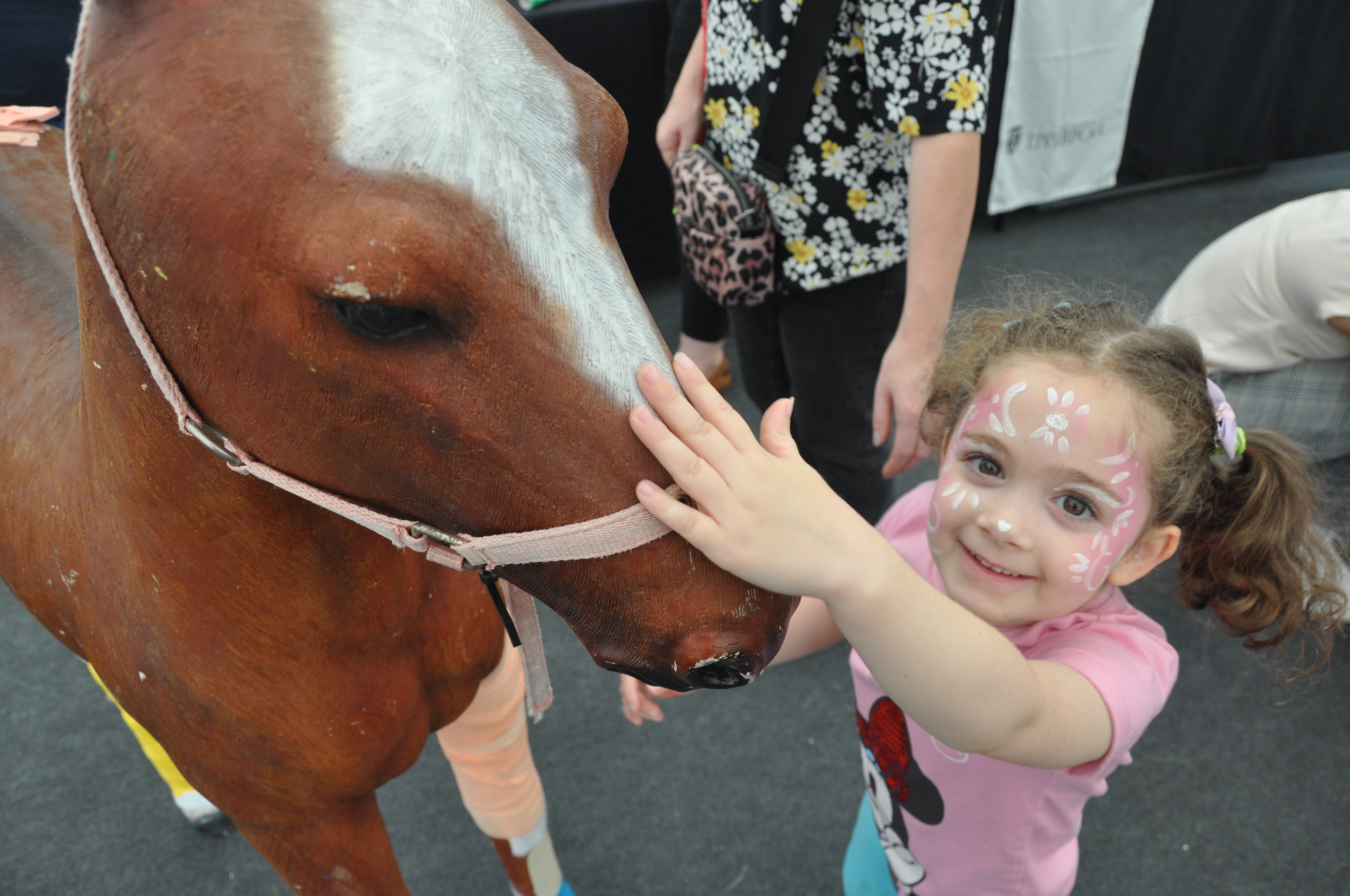 A child touching a simulation horse