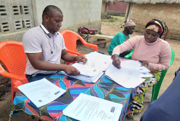 Vaccine research team sitting outdoors at table with paperwork