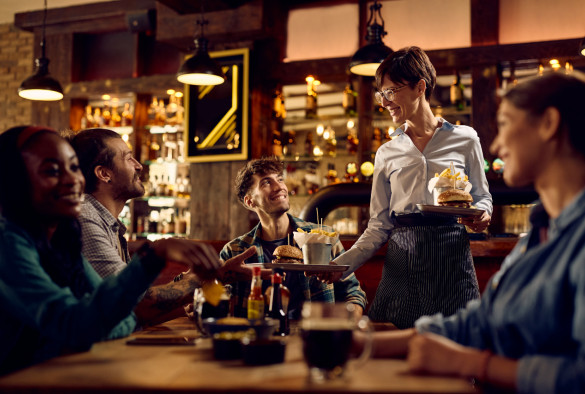 Group of people being served food at a restaurant