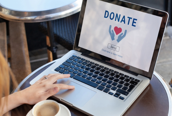 A laptop with donate written on the screen to show charity giving