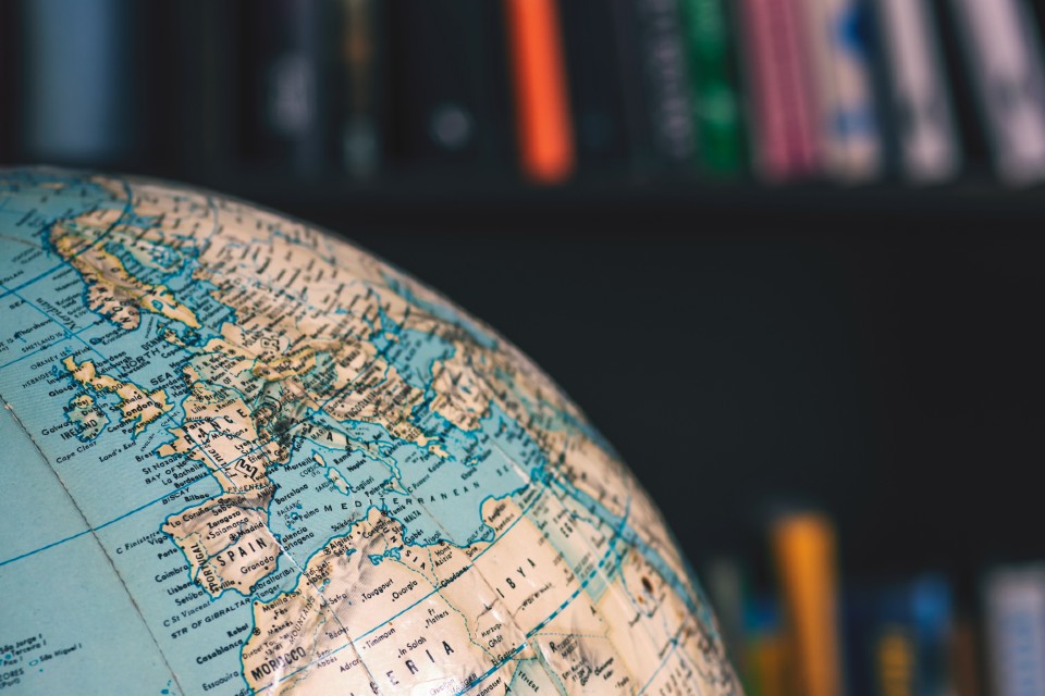 Section of globe in front of some library bookshelves