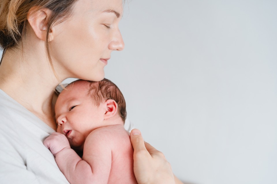 A woman holding a newborn baby